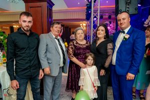 Family group photo at an elegant event with purple lighting and formal attire.