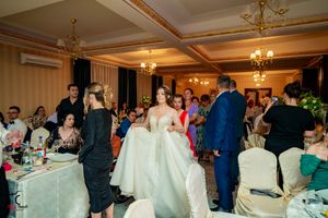 Elegant banquet hall with chandeliers and formal table settings for a special event.