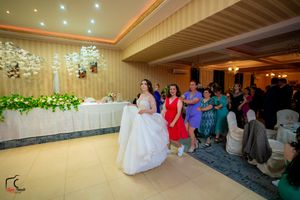 Spacious banquet hall with elegant lighting, striped wallpaper, and floral decorations.