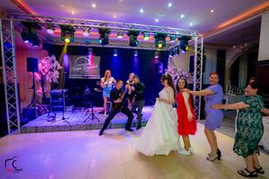 Dancers perform at an elegant ballroom event with colorful purple and blue lighting and professional stage equipment.
