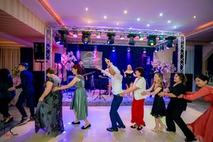 Elegant ballroom dance event captured in wide angle showing dancers under dramatic purple lighting.