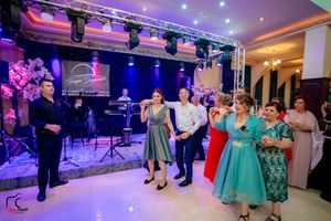 Formal dance event in an elegant venue with purple and blue lighting effects.