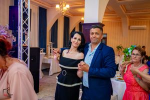 Couples dancing in formal attire at an elegant ballroom reception with ambient lighting.
