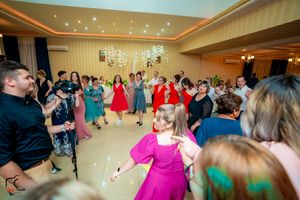 Wedding celebration in a grand ballroom with twinkling ceiling lights and dancing guests.