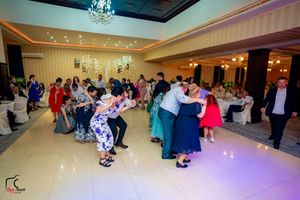 Ballroom celebration with guests dancing under sparkling ceiling lights and chandeliers.