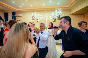 Partygoers singing and celebrating enthusiastically during a festive indoor event.