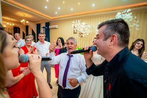 Entertainment performers engaging with excited party guests during a celebratory indoor event.