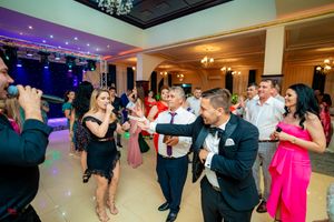 Festive celebration with guests dancing and enjoying entertainment in a beautifully lit ballroom.