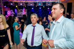 Guests enjoying upbeat entertainment at a formal indoor celebration with colorful lighting.