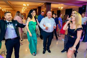 Wedding celebration in full swing with guests dancing in an elegantly lit ballroom setting.