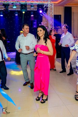 Wedding party guests dancing on illuminated dance floor with professional lighting and sound equipment.