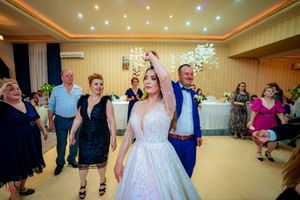 Joyful celebration on the dance floor at a wedding reception with sparkly decor and ambient lighting.