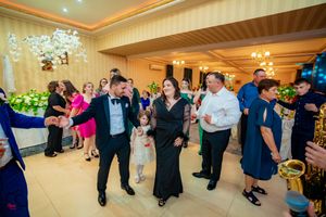Wedding guests enjoying themselves on the dance floor at an indoor reception venue.