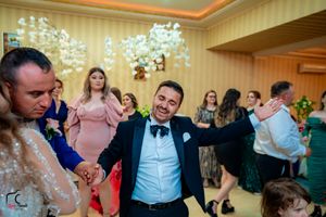 Energetic dancing and celebration at a wedding reception with decorative lighting.