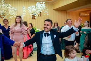 Wedding reception guests dancing and celebrating in a warmly lit ballroom.