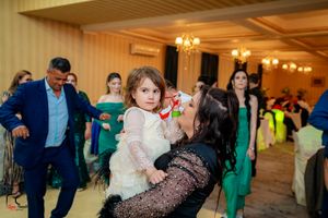 Lively dance floor moment at a wedding reception with guests in formal attire.