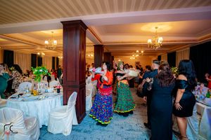 Wedding reception with traditional dancers performing in colorful dresses on the dance floor.