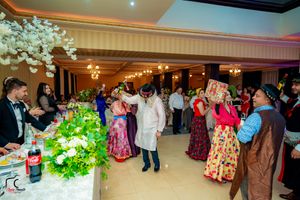 Banquet hall decorated with white floral arrangements and warm lighting for an evening celebration.