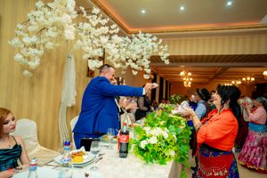 Elegant banquet setup with hanging lights and floral centerpieces during an evening celebration.