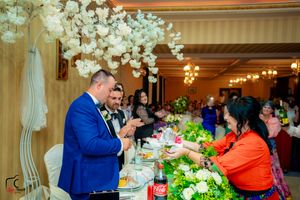 Reception venue with ornate lighting fixtures and decorative white floral arrangements.