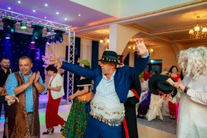 Elegant indoor party venue with purple ambient lighting and chandeliers.