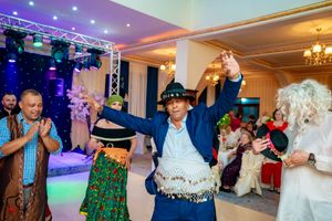 Social gathering in a ballroom with vibrant lighting and traditional folk dancers.