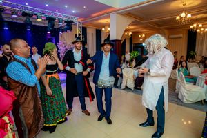 Indoor dance party with traditional costumes and professional stage lighting setup.