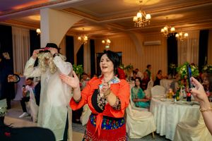 Festive celebration in a banquet hall with colorful lighting and guests enjoying the dance floor.