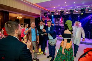 Panoramic view of an elegant wedding reception venue with purple accent lighting and dance floor.