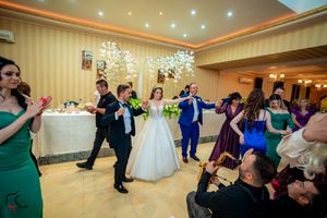 Wedding reception panorama showing dance floor and elegant decor with purple accent lighting.