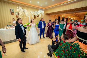 Panoramic view of wedding guests dancing and celebrating in an elegantly decorated ballroom.