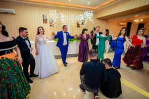 Wedding party dancing and celebrating in an elegantly lit reception hall.
