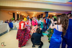 Wide angle shot of wedding reception with guests dancing under ambient lighting.