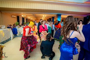Panoramic view of wedding guests dancing and mingling in a decorated ballroom.