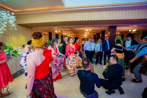 Wide angle shot of dancers moving across a spacious ballroom floor during an evening event.