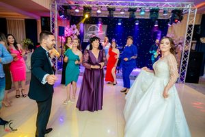 Wedding reception dance floor with dramatic lighting and guests in formal attire.
