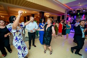 Dancers performing synchronized moves in a brightly lit ballroom during a formal event.