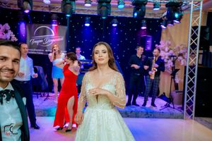 Wedding celebration in a ballroom with dramatic blue and purple lighting creating a festive atmosphere.