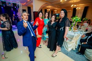 Wedding guests socializing and celebrating in an elegantly decorated reception venue with mood lighting.