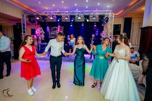 Guests enjoying a lively dance moment at an elegant wedding reception with colorful lighting.