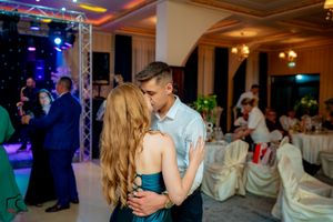 Romantic slow dance moment at wedding reception with ambient lighting.