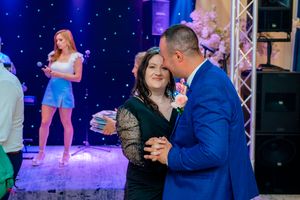 Dance floor scene with couples enjoying themselves under dramatic blue lighting and stage equipment.