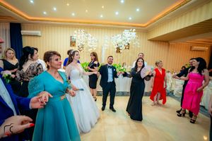 Ballroom dance party with guests in formal attire enjoying festivities under elegant lighting.