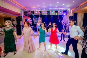 Wedding reception dance floor panorama showing guests celebrating under purple and blue mood lighting.