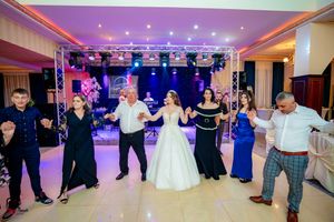 Wide view of a wedding reception showing guests dancing under theatrical lighting and truss system.