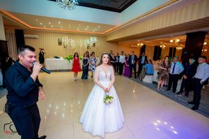 Wedding celebration in an elegant ballroom with crystal chandeliers and ambient lighting.
