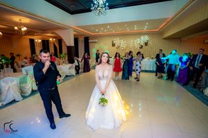 Wedding celebration in an elegant ballroom with dramatic lighting and festive atmosphere.