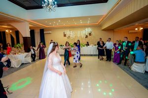 Wedding reception dance floor with green lighting effects and guests celebrating.