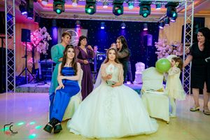 Wedding reception scene with colorful stage lighting and formal celebration atmosphere.