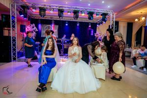 Wedding reception venue with colorful purple and blue lighting featuring a dance floor and stage setup.